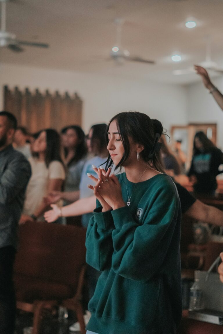 Woman in green praying with others in a church